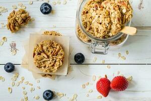 Homemade granola bar and fresh berries on wood table with space. photo