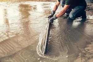 plasterer concrete worker at floor of house construction photo