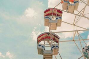 Ferris wheel on cloudy sky background with vintage toned. photo