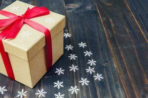 Christmas gift box placed and white snowflakes on wooden planks with space. photo