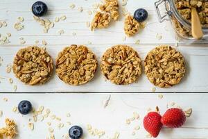 Homemade granola bar and fresh berries on wood table with space. photo