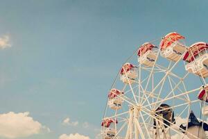 Ferris wheel on cloudy sky background with vintage toned. photo