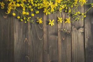 Yellow flower on wooden background with space with vintage toned. photo