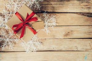 Christmas gift boxes placed and white snowflakes on wooden planks with space. photo