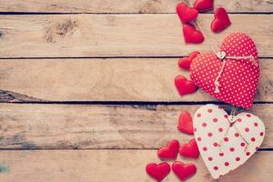 Heart fabric frame on wooden table background. photo