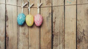 Easter egg hanging on wooden background with copy space photo