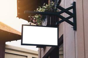 Empty signage and blank mock up hanging on street with copy space photo