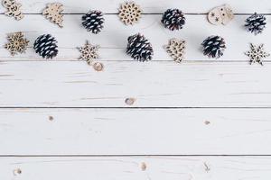 Wooden white and christmas background with snowflakes, pine cones and christmas decoration. photo