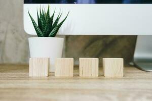 Four wooden toy cubes on wooden table background with copy space photo
