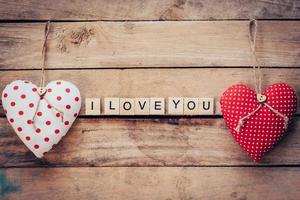 Heart fabric and wooden text I LOVE YOU on wooden table background. photo