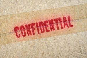 Red Confidential word printed on brown vintage envelope. photo