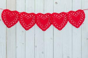 rojo corazón colgando en blanco madera para celebracion con espacio. foto