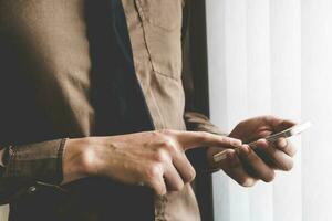 Businessman holding phone at window. Creative Business Startup Idea. photo