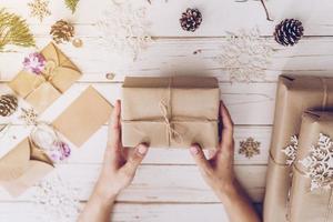 Woman hand holding beautiful Christmas gift box at table photo