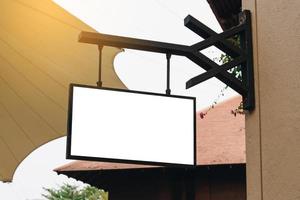 Empty signage and blank mock up hanging on street with copy space photo