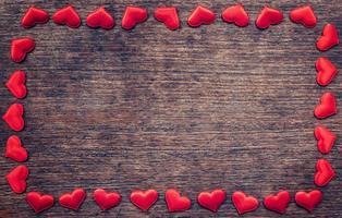 Frame of red heart on wooden background with copyspace. photo