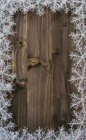 de madera marrón Navidad antecedentes y blanco copos de nieve con espacio. foto