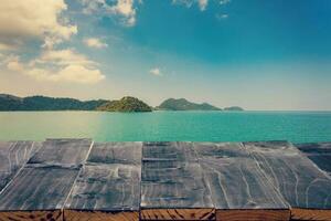 Empty Top of wood table with sea and island. For Product display montage. Beach in summer Concept. photo