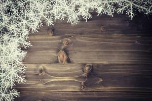 Wooden brown christmas background and white snowflakes with space. photo