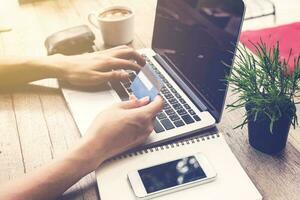 Man holding credit card and using laptop. Online payment. photo