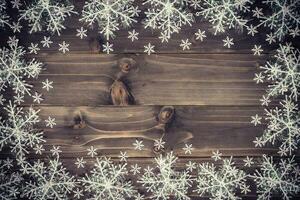 Wooden brown christmas background and white snowflakes with space. photo