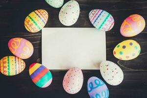 huevos Pascua de Resurrección y blanco papel en madera antecedentes con espacio de copia. foto