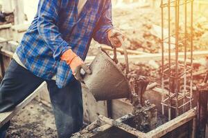 masón o yesero verter construcción cemento en piso. foto