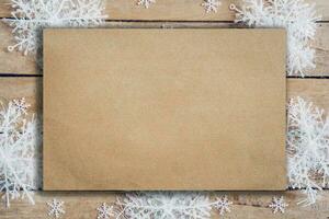 Wooden brown christmas background with snowflakes and old brown paper with space. photo