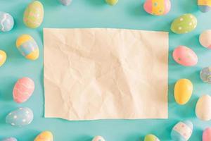 Coloeful easter eggs and brown paper on pastel color background with space. photo