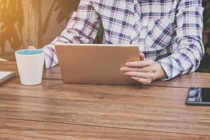 Asia woman holding tablet on table in coffee shop photo