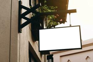 Empty signage and blank mock up hanging on street with copy space photo