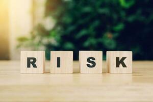 Word RISK block wood on wooden table background. RISK Business concept. photo