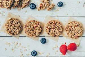 Homemade granola bar and fresh berries on wood table with space. photo