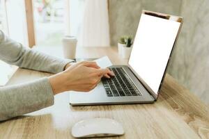 Woman using credit card on laptop for shopping online photo