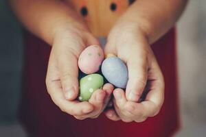 Little girl hands holding easter eggs painted color on hand photo
