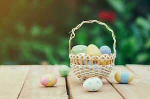 Colorful easter eggs in basket on wooden table win copy space. photo