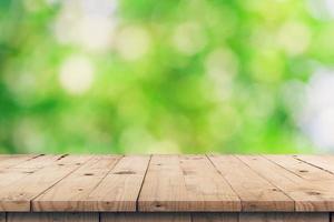 Empty wooden table top and green bokeh display montage for product with space. photo