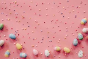 Pastel Easter eggs on pink background top view with natural light. Flat lay style. photo