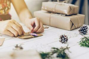 mujer mano haciendo hermosa Navidad tarjeta a mesa foto