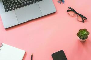 Flat lay design of workspace desk with laptop, blank notebook, smartphone, pencil, stationery with copy space background photo