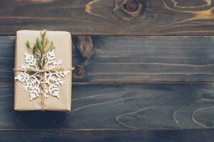 String or twine tied in a bow on kraft paper. Above gift box on wood with space. photo