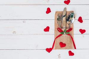 encima madera mesa conjunto cubiertos y rojo corazón para enamorado día con espacio. foto