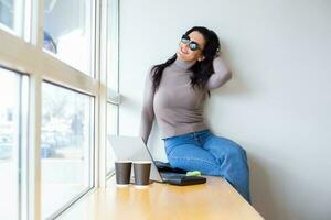 Beautiful businesswoman working on a laptop. Female freelancer connecting to internet via computer. Blogger or journalist writing new article. photo