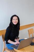 Beautiful businesswoman working on a laptop. Female freelancer connecting to internet via computer. Blogger or journalist writing new article. photo