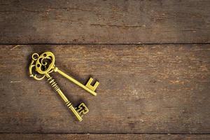 old vintage key on wood background with space photo