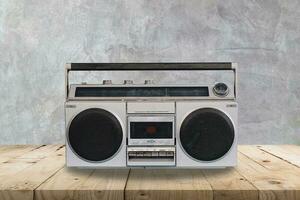 Vintage stereo on wooden table and concrete  wall texture and background.