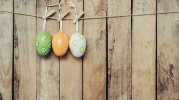 Easter egg hanging on wooden background with copy space photo