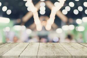 Empty wooden table with blurred abstract people on cafe on restaurant background. photo