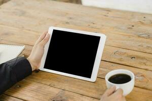 business man using tablet on wood table in coffee shop. photo