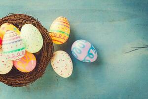 vistoso Pascua de Resurrección huevos en nido en azul madera antecedentes con Copiar espacio.